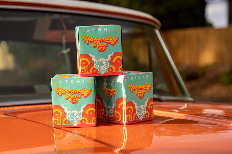 Stone Neverending Haze IPA four-packs on a vintage car